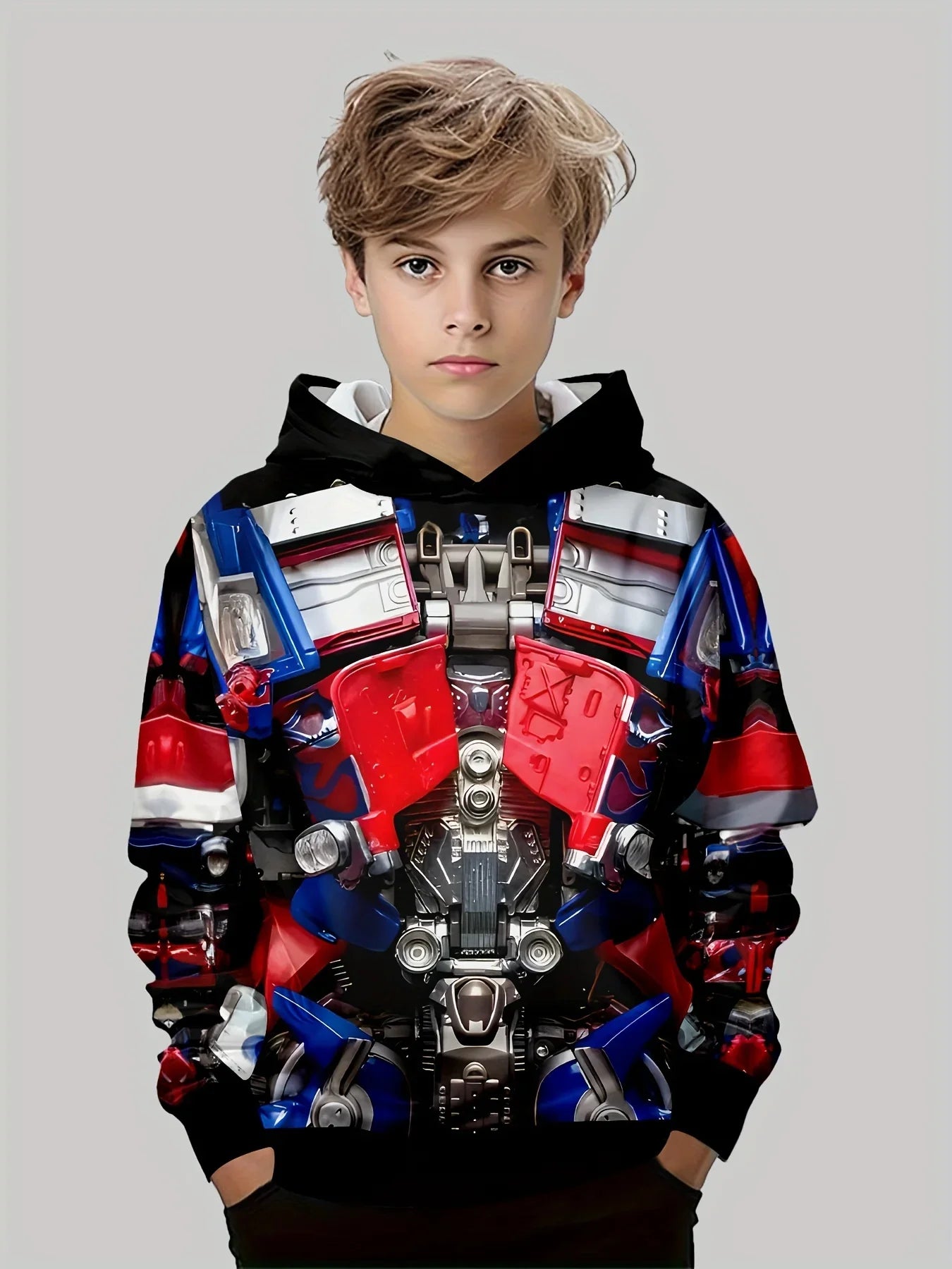 Sweat à capuche enfant Transformers, motif robot rouge et bleu, garçon debout sur fond gris – Transformers.
