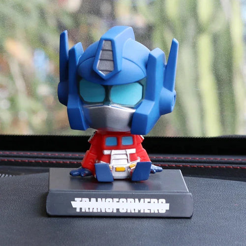 Figurine Optimus Prime bleu et rouge assise sur un socle, style cartoon, sur tableau de bord – Transformers.