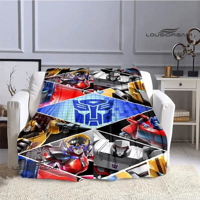 Plaid Transformers coloré sur fauteuil, motifs de robots et logo bleu au centre – Transformers.