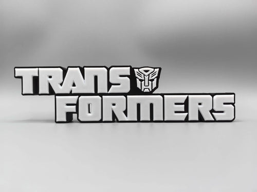 Tabliczka Transformers z monochromatycznym srebrnym logo — Metalizowana dekoracja na biurko