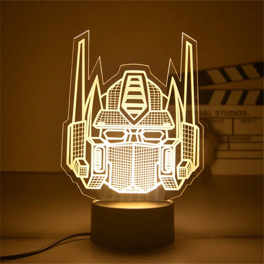 Lampe LED silhouette tête Optimus Prime, lumière jaune sur socle noir, style moderne – Transformers.