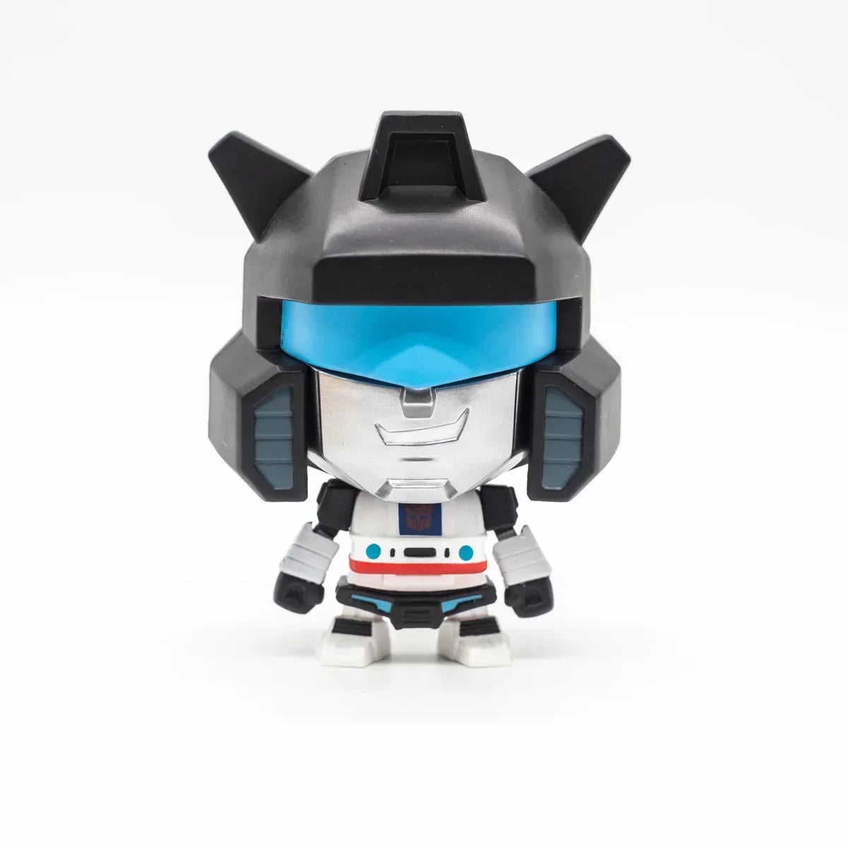 Figurine chibi robot argenté et noir, visière bleue, sur fond blanc – Transformers.