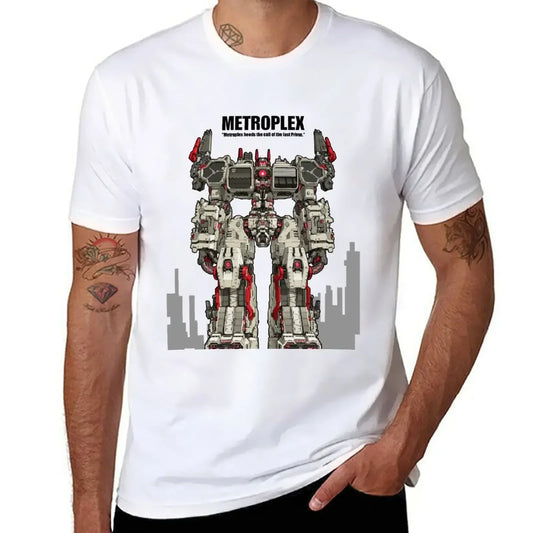 T-shirt blanc avec impression du robot Metroplex debout, décor urbain en fond, style comics – Transformers.